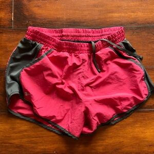 Selling two pairs of red and purple athletic shorts.